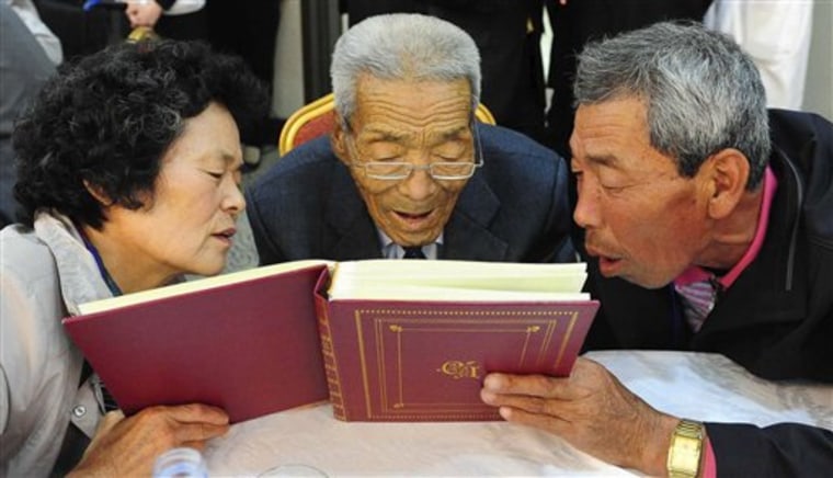 North Korean father Ri Jong Ryol, center, looks at a photo album with his South Korean son Lee Min-gwan, right, and daughter Lee Sun-ja, left, during the Separated Family Reunion Meeting at Diamond Mountain in North Korea, Saturday. Hundreds of Korean family members separated for more than half a century by the Korean War hugged and embraced each other in tearful reunions Saturday, a day after troops exchanged gunfire in the Demilitarized Zone dividing the countries. 